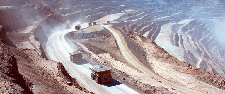 Aerial View Of Opencast Mining Quarry With Lota Of Machinery At Work.