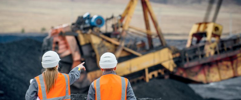 Two Mining Engineers Discussing While Pointing Some Mining Process.